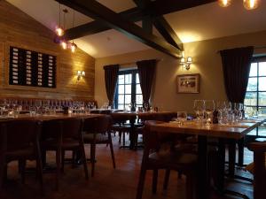 a restaurant with wooden tables and chairs with wine glasses at The Angel Inn in Warminster