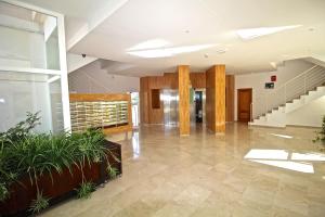 an empty lobby with stairs and plants at Residence Vacanza Torre Monaco in Benidorm +25 photos