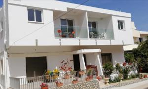 a white house with chairs on a balcony at Chicos Studios in Ayia Napa