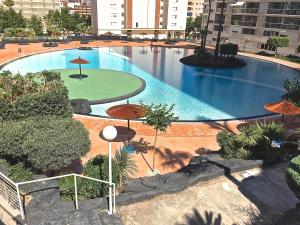 a large swimming pool with umbrellas in a city at Residence Vacanza Torre Monaco in Benidorm