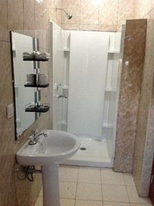 a bathroom with a white sink and a shower at ShaMooL Hotel in Dar es Salaam