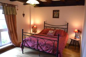 a bedroom with a bed with a red comforter at Chambres d'Hôtes S'burehiesel in Schillersdorf