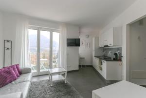 a living room with a couch and a kitchen at Minerva Residence in Lavena Ponte Tresa