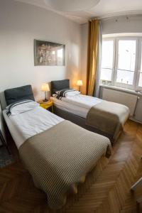 - 2 lits dans une chambre avec fenêtre dans l'établissement Rondo Mogilskie Apartment, à Cracovie