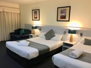 um quarto de hotel com duas camas e um sofá em Lakeview Motor Inn em Belmont