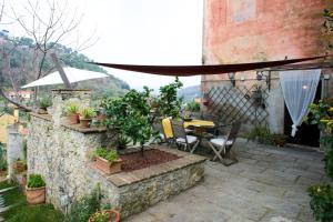 a patio with a table and chairs on a stone wall at I Glicini in Lerici