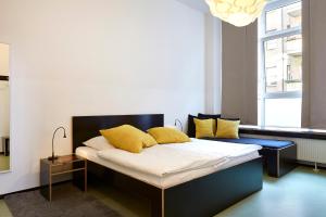 Un dormitorio con una cama con almohadas amarillas. en Hüttenpalast, en Berlín