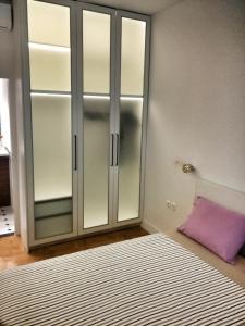 sypialnia z przeszkloną szafą i fioletową poduszką w obiekcie Central new Kolonaki apartment w Atenach
