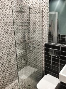a bathroom with a shower with black and white tiles at Central new Kolonaki apartment in Athens