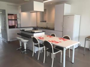 a kitchen with a table with chairs and a refrigerator at Chantal in Brun Culot