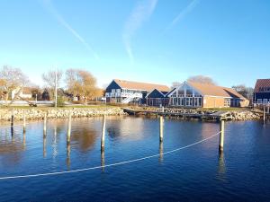 a group of poles in the water next to a building at Klintholm Marina Park Cabins in Borre