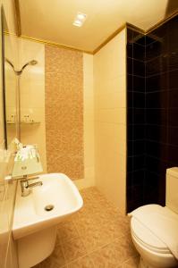 a bathroom with a white sink and a toilet at Appleton Boutique Hotel Mactan Cebu in Mactan