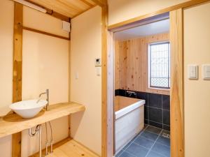 een badkamer met een wastafel en een bad bij NIPPONIA Sawara Merchant Town Hotel in Katori