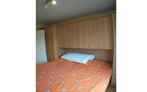 1 dormitorio con cama naranja y almohada azul en Residence Calidris ref 48, en Koksijde