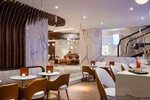 a restaurant with tables and chairs and a couch at Hôtel Barrière Le Gray d'Albion in Cannes