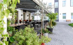an outdoor patio with tables and chairs and plants at Maverick Budapest Soho in Budapest