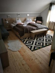 a bedroom with a large bed and a rug at Pensiune Restaurant La Cassa in Vişeu de Sus