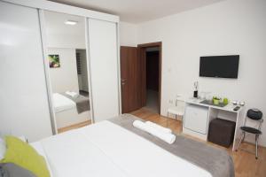Schlafzimmer mit einem Bett, einem Schreibtisch und einem TV in der Unterkunft Vila Vanila in Gevgelija