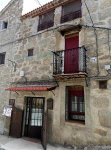 an old stone building with windows and a balcony at Casa Rural Neveritas in Piedrahita
