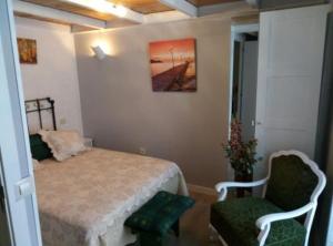 ピエドライタにあるCasa Rural Neveritasのベッドルーム1室(ベッド1台、椅子2脚付)