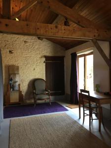 a living room with a table and chairs and a window at Dormir Ben Aise Hammam Massages in Maillezais