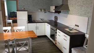 cocina con armarios blancos y mesa de madera en Historical Apartment, en Gummersbach