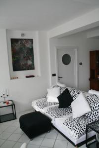 Camera bianca con letto e cuscini bianchi e neri. di Casetta bianca sul mare a Bogliasco