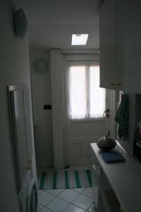 a small kitchen with a door and a window at Casetta bianca sul mare in Bogliasco