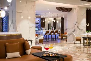 a hotel lobby with a bar with wine glasses on a table at Hôtel Barrière Le Gray d'Albion in Cannes