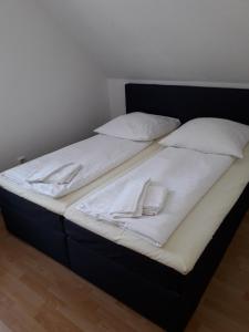 ein Bett mit weißer Bettwäsche und Kissen darauf in der Unterkunft Ferienpark Tannenbruchsee in Neustadt am Rübenberge