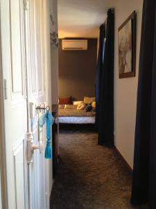 pasillo con puerta y dormitorio con cama en Au Lavoir, en Colombiers