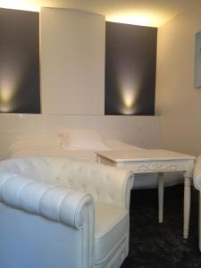 a living room with a white couch and a table at Au Lavoir in Colombiers