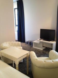 a living room with two chairs and a television at Au Lavoir in Colombiers