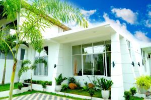 a white house with palm trees in front of it at Airport 4 Season Transit Hotel in Katunayake