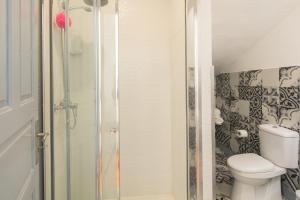 uma casa de banho com um WC e uma cabina de duche em vidro. em A Francos Burguer Station 2 no Porto