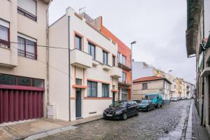 a street with two cars parked next to buildings at A Francos Burguer Station 2 in Porto