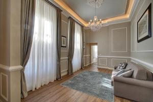 een woonkamer met een bank en een kroonluchter bij Art Apartment Luxury Family suite in Florence