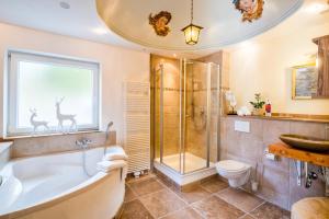 a bathroom with a tub and a shower and a sink at Zur Schönen Aussicht Hotel garni in Garmisch-Partenkirchen