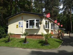 a small house with palm trees in front of it at California Chalet & Touring Park in Wokingham