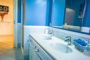niebieska łazienka z 2 umywalkami i lustrem w obiekcie La Residenza Dei Mori - Taormina Holidays w Taominie