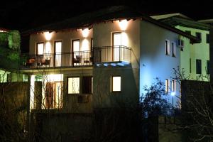 a large white house with lights on it at night at Pansion Villa Nur in Mostar