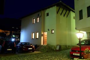 a building with cars parked in front of it at night at Pansion Villa Nur in Mostar
