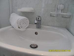 ein weißes Waschbecken mit einem Handtuch darüber in der Unterkunft Sea View Room Macolic in Rab
