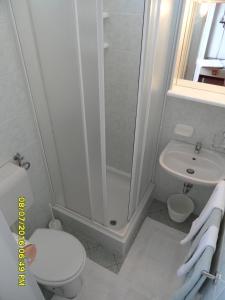 La salle de bains est pourvue d'une douche, de toilettes et d'un lavabo. dans l'établissement Sea View Room Macolic, à Rab