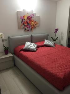 シルミオーネにあるLuxury Apartments La Victoriaのベッドルーム1室(赤い掛け布団付きのベッド1台付)