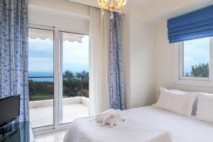 a bedroom with a bed and a large window at Blue Luxury Maison in Possidi