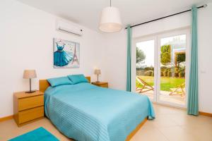a bedroom with a bed and a sliding glass door at Cabanas Gardens by Algartur in Cabanas de Tavira +108 photos