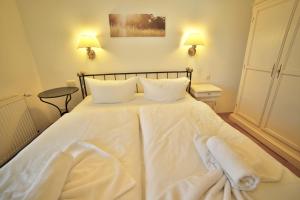 a white bed with white sheets and towels on it at Binzer Strandgut in Binz