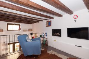 ein Wohnzimmer mit einem blauen Stuhl und einem Flachbild-TV in der Unterkunft Casetta di Chico in Palermo