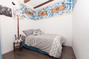 Schlafzimmer mit einem Bett mit einer blauen und weißen Bettdecke in der Unterkunft Casetta di Chico in Palermo